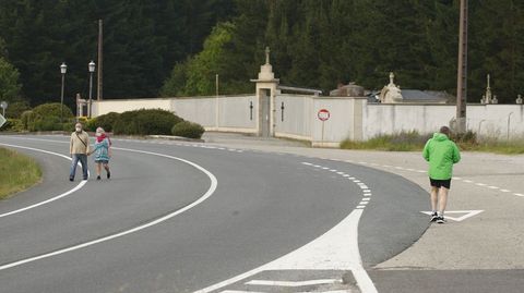 Unos peatones cruzan la carretera junto al cementerio parroquial de Chantada