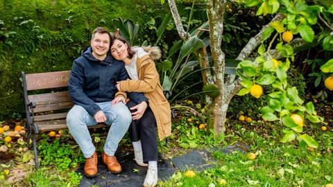 La pareja en un banco de la finca de su casa.