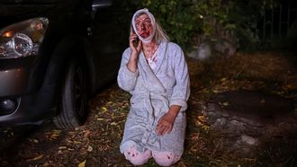 Una mujer en pijama y herida al tener que salir de su casa en Kiev tras el bombardeo de un bloque de apartamentos