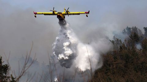 Un hidroavi�n durante las tareas de extinci�n de un incendio declarado en los montes pr�ximos a la localidad c�ntabra de Penilla