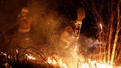 Los bomberos intentan sofocar el incendio que se ha producido hoy en los alrededores de Labares