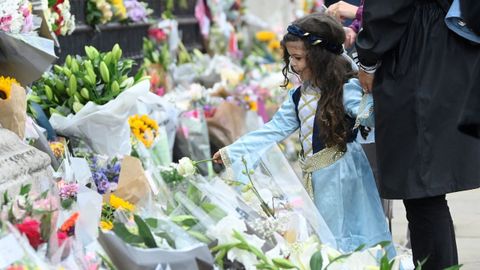 Los exteriores de la residencia oficial de la monarqu�a se han convertido este jueves en lugar de reuni�n no solo de turistas, como es habitual, sino sobre todo de personas que han querido dejar su homenaje a la reina, como esta ni�a.
