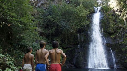 Un grupo de bañistas frente a la casca de Vieiros