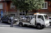 Un agente municipal observa la retirada de un veh�culo por una gr�a de Vendex.