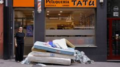 Lorena Montero, propietaria de la peluquer�a Tat�, con el mont�n de colchones a las puertas de su negocio despu�s de que los okupas los lanzaran por la ventana