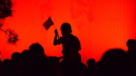 Un nio sujeta una bandera en la plaza de Tiananmen en los actos previos al 70 aniversario