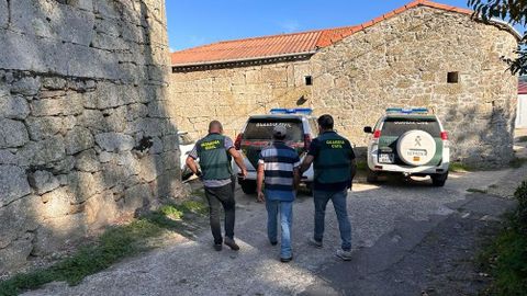 Agentes del Seprona de la Guardia Civil con el sospechoso detenido por causar incendios en un pueblo de Xinzo de Limia.