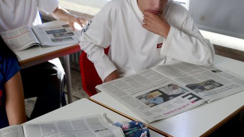 Un ni�o lee  La Voz de la Escuela  en un colegio coru��s.