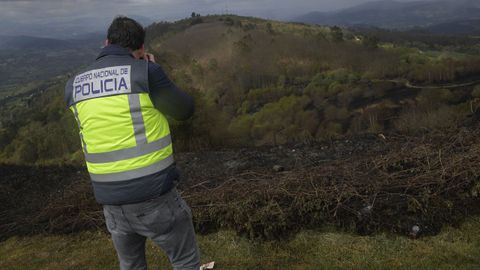 Un miembro de la Polica Cientfica filma la zona arrasada por el fuego en la cima del Monte Naranco