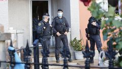 Adri�n Out�n, ayer en su casa, esposado durante el registro practicado por decenas de agentes 