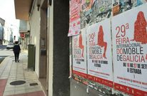 En los escaparates de A Estrada ya lucen los carteles promocionales de la Feira do Moble en gallego. 