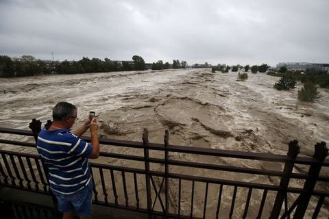 Un hombre toma una foto en un puente del r�o Var, desbordado, en los alrededores de Niza (Francia) 