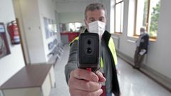 Un trabajador municipal, este lunes con el aparato que toma la temperatura corporal de quienes entran en el ayuntamiento de Monforte