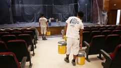 Operarios este mi�rcoles acometiendo el pintado en el sal�n de actos del centro c�vico de Caranza.