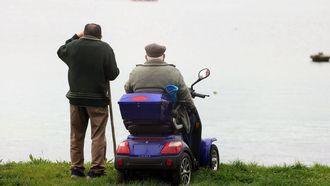 Imagen de archivo de dos personas mayores contemplando el mar.