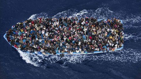 Una barcaza llena de n�ufragos siendo rescatados al norte de Libia por una fragata de la marina italiana.