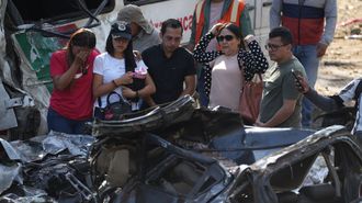Familiares de las v�ctimas del atentado ocurrido en la V�a Panamericana lloran este domingo frente a los escombros de los veh�culos destruidos en la localidad colombiana de Cajib�o