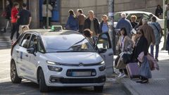 Tres clientas, cogiendo un taxi en la parada que se encuentra en la praza de Galicia