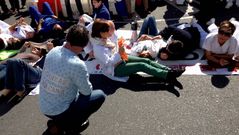 Los trabajadores se acostaron sobre el asfalto para protestar por el cierre de 211 camas durante el verano