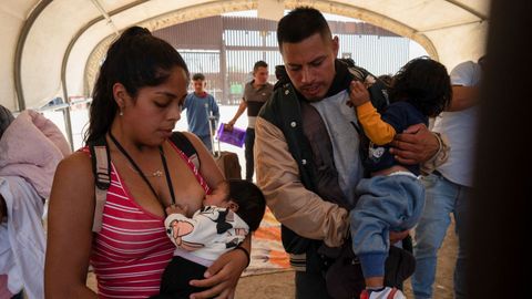 Los peruanos Fiodella L�pez y Alexis Asuedo esperan con sus hijos para ser procesados ??por agentes de la patrulla fronteriza de EE. UU. en San Luis (Arizona).