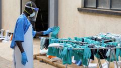 Un sanitario recoge equipo de protecci�n desinfectado en Uganda