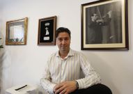 Luis Cota, en su despacho, entre el retrato de Manuel Quiroga  y el Premio Cidade de Pontevedra. 