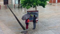 Una pareja de turistas consultando un panel informativo en la plaza de Espa�a de Monforte