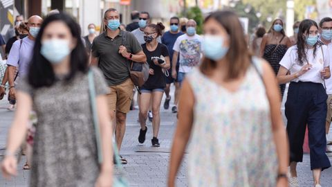 Varias personas caminan con mascarillas