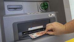Una persona retira dinero en un cajero de Santiago.