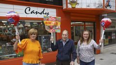 El fundador de Candy posa junto a sus actuales dependientas, Mercedes Villar (izquierda) y Olaya Iglesias (derecha), delante de la reconocible tienda de golosinas.  Ambas suman a�os y vivencias tras el mostrador: �Adultos que eran ni�os en los 80 regresan ahora con sus hijos�.