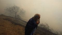 El incendio de Larouco, que empez a las 18.55 horas, acab llegando a Vilar de Mondelo, en Quiroga, donde un vecino se protege del humo con mascarilla.
