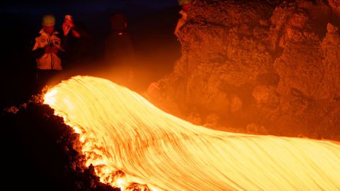 Un grupo de personas observa c�mo fluye la lava tras la erupci�n del volc�n