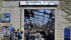 Varios miembros de la empresa Recambios al Volante frente a su nave, totalmente calcinada. 