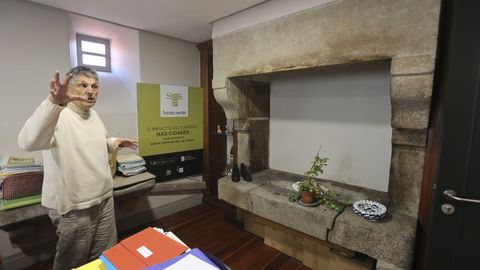Suso Amado, técnico de Cultura del Concello de Santiago, muestra la lareira conservada de la antigua casa del conserje