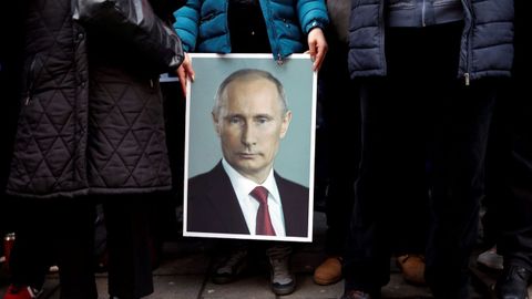 Un partidario del presidente ruso Vladimir Putin sostiene su retrato en Belgrado, Serbia
