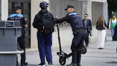 Dos polic�as locales junto a un conductor de un patinete el�ctrico