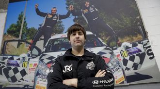 Daniel Berdom�s, en su taller ante una fotograf�a de su propio equipo tras ganar un rali.