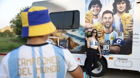 Aficionados argentinos se hacen fotos con un cartel en el que aparecen Maradona, Kempes y Messi.