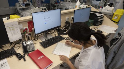Una sanitaria del Hospital Clnic de Barcelona trabaja tomando notas a mano tras el ciberataque