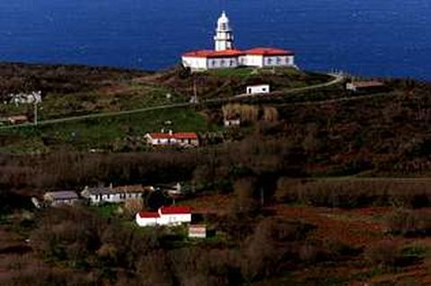 Viviendas de la isla de Ons con el faro al fondo