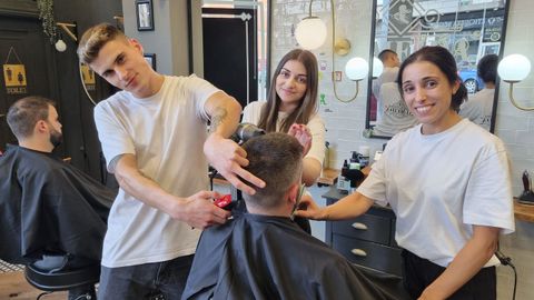 Noé, Cristina y Tania, con uno de los clientes de la Barbería Almeida