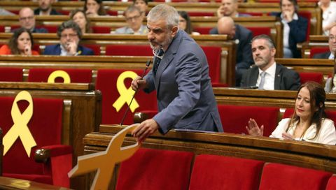 Momento en el que Carlos Carrizosa retira un lazo amarillo colocado en el banco del Govern
