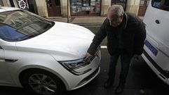 El propietario del taxi se�ala el lugar en que impacto la teja en su coche