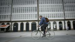 Un hombre pasea en bicicleta por la Marina, en A Coru�a