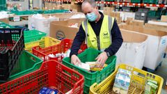 Voluntarios del Banco de Alimentos de Asturias trabajan en el almac�n que tienen en el pol�gono de Argame en Oviedo