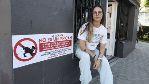 Lola Muñoz, junto al cartel que ha colocado en la fachada de su negocio.