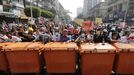 Los manifestantes detr�s de una barrera de contenedores mientras se enfrentan a la polic�a antidisturbios durante una protesta en Rang�n