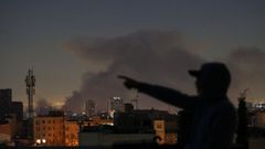 Un hombre se�ala el humo de una explosi�n en Teh�ran la madrugada del viernes