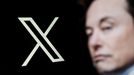 Elon Musk ante un logo de la red social X