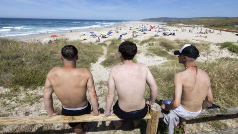 Tres j�venes observan la playa en Razo, Carballo